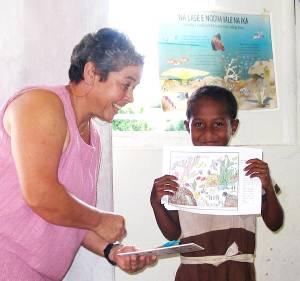  Christine Tawake of Lawaki Beach House presenting Class 3 student of Uluinakorovatu School with Butterflyfish slate for her best coloring in of coral reef inhabitants.